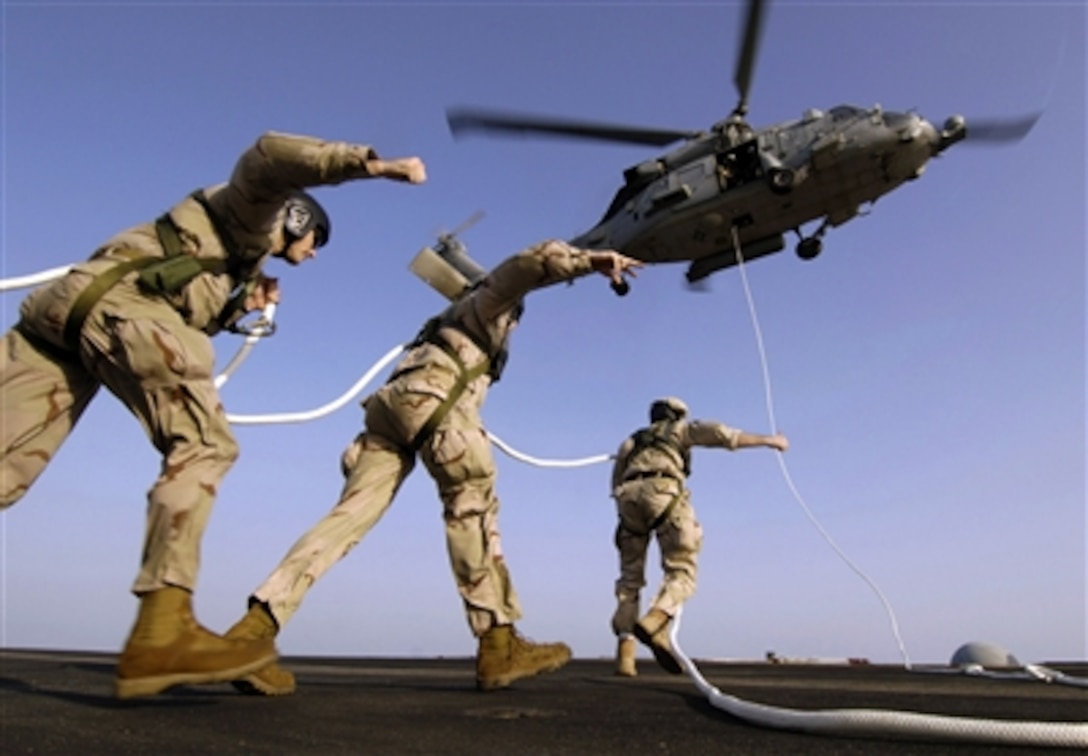 Sailors move toward an HH-60H Seahawk during Special Purpose Insertion/Extraction (SPIE) training aboard the nuclear-powered aircraft carrier USS Enterprise in the Arabian Sea, Sept. 23, 2006. 