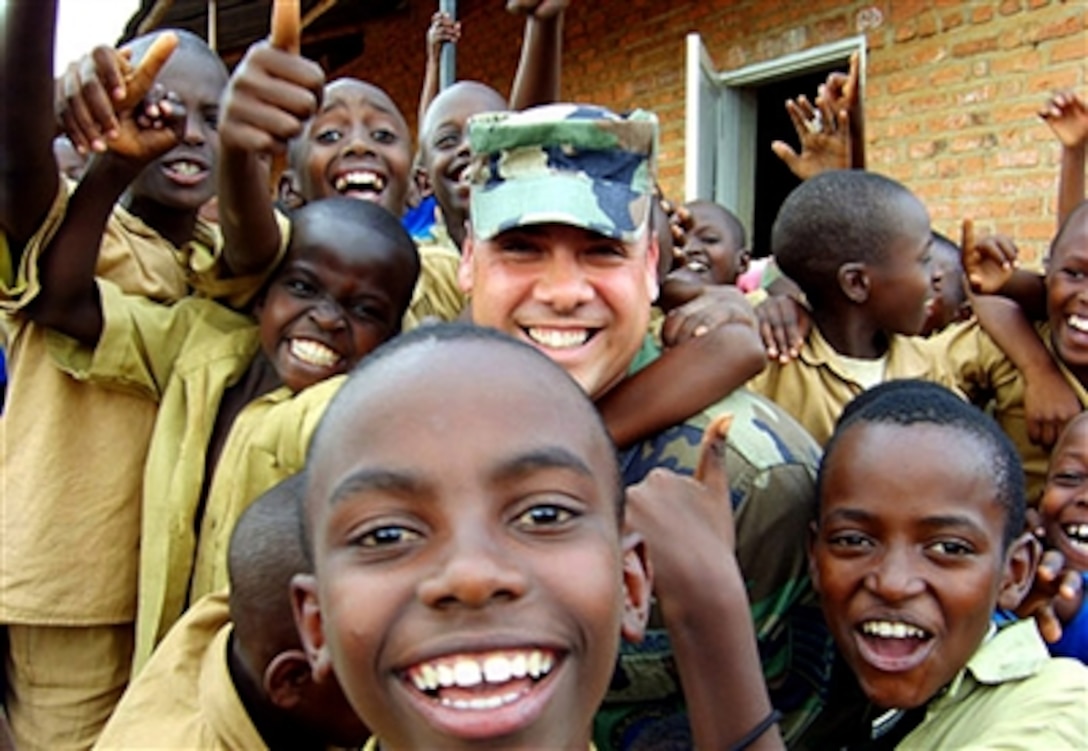 School children surround Tech. Sgt. Hector Nieves at their Kigali, Rwanda, school where airmen from Ramstein Air Base, Germany, delivered school supplies, Sept. 22, 2006.
