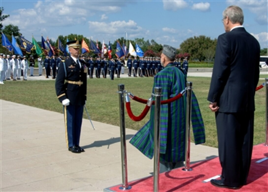 Secretary of Defense Donald H. Rumsfeld, right, and President of Afghanistan Hamid Karzai, center, attend a full honor cordon at the Pentagon Sept. 25, 2006.  