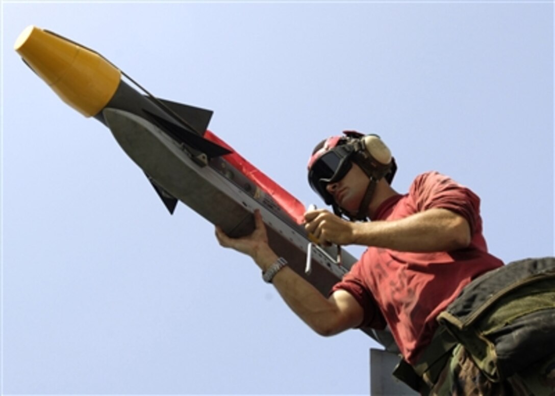 Navy Petty Officer 3rd Class Nick Rowland attaches an AIM-9 Sidewinder missile to an F/A-18F Super Hornet aircraft on the flight deck of the aircraft carrier USS Enterprise (CVN 65) as the ship operates in the Persian Gulf on Sept. 21, 2006.  