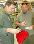 Col. Michael Shanahan, 60th Air Mobility Wing C-17 program office, presents Sammy Hagar, with a C-17 video  'Anywhere Anytime' created by Boeing to the tune of his hit song, 'I can't drive 55,' at Travis Air Force Base. (U.S. Air Force photo by Staff Sgt. Matt McGovern/60th AMW public affairs)