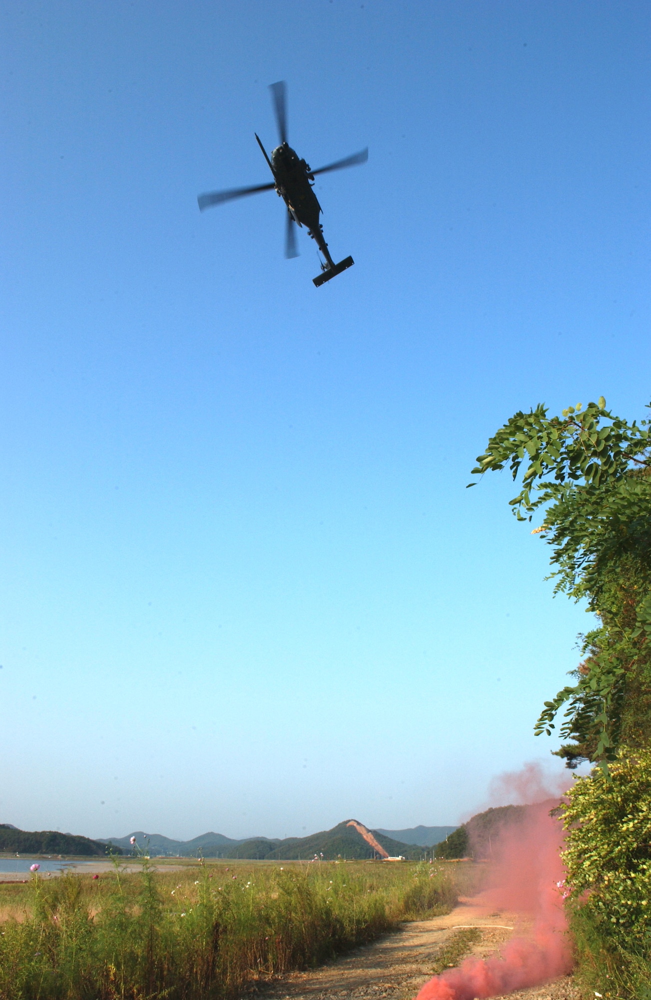 An HH-60 Pavehawk crew prepares to recover two survivors during combat search and rescue training Sept. 21 near Osan Air Base, South Korea. Annual training is conducted by survival, evasion, resistance and escape instructors to reacquaint aircrew members with combat search and rescue procedures and techniques. (U.S. Air Force photo/Airman 1st Class Chad Strohmeyer)
