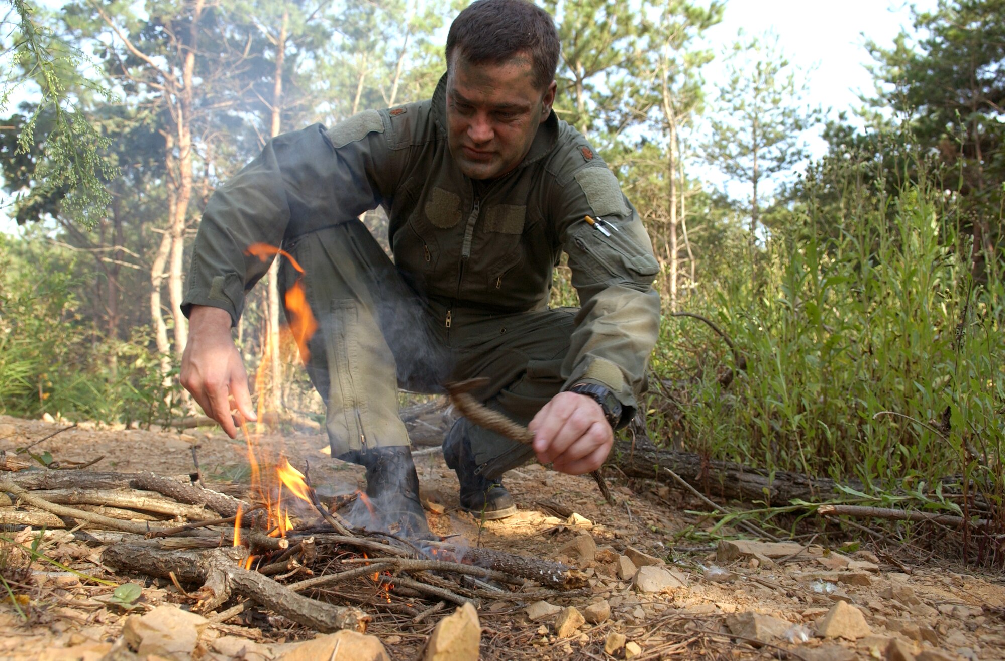 Maj. Paul Neidhardt starts a fire using a block of flint during combat search and rescue training Sept. 21 near Osan Air Base, South Korea. Annual training is conducted by survival, evasion, resistance and escape instructors to reacquaint aircrew members with combat search and rescue procedures and techniques. Major Neidhardt is with the 25th Fighter Squadron at Osan AB. (U.S. Air Force photo/Airman 1st Class Chad Strohmeyer)
