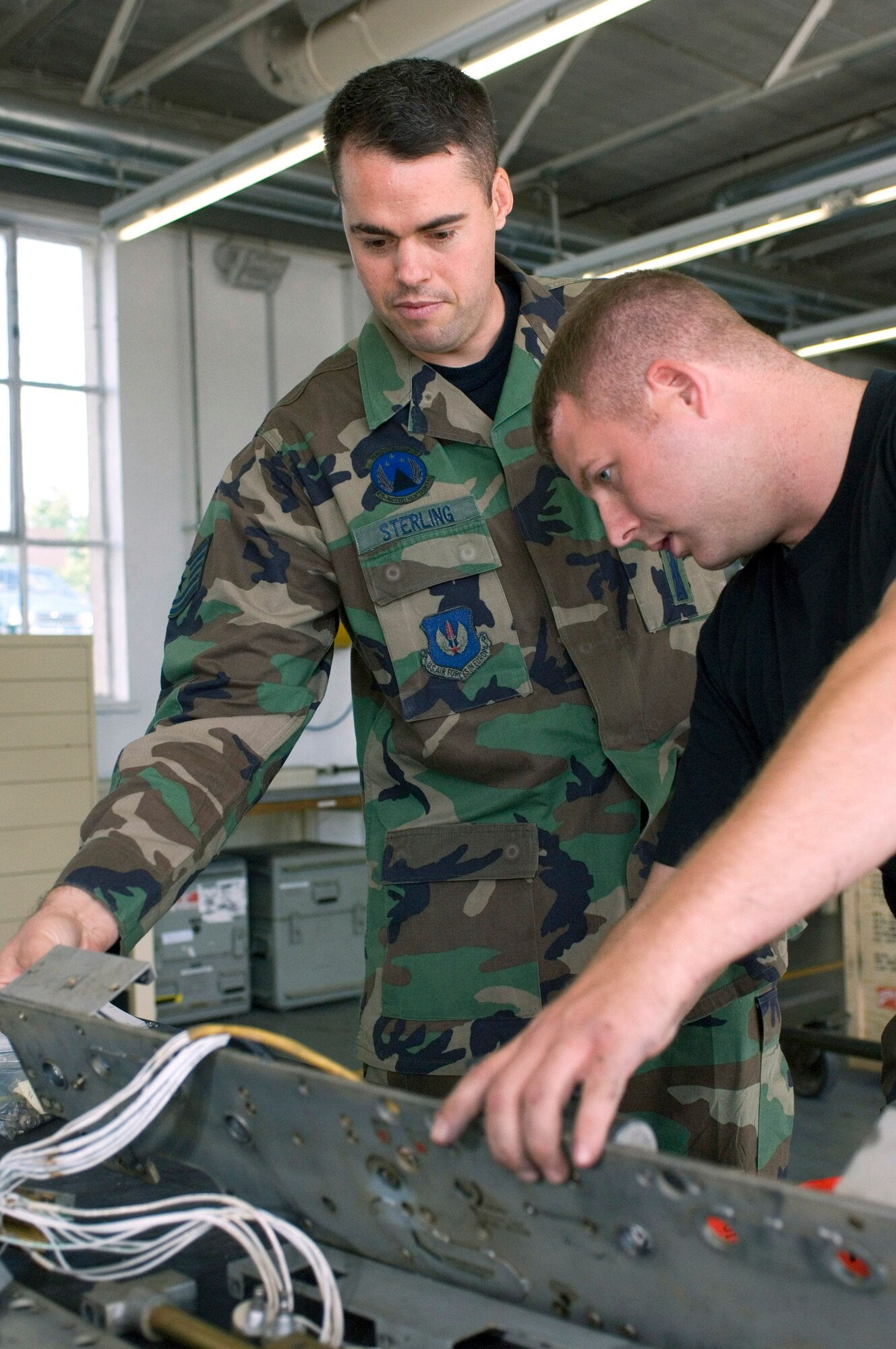 Tech. Sgt. Daniel Sterling (left) and Senior Airman Robert Langham prepare to rewire a bomb rack Sept. 20 at Sembach Air Base, Germany, ensuring it's ready for immediate worldwide deployment. Sergeant Sterling and Airman Langham are aircraft armament systems specialists with Sembach's 435th Materiel Maintenance Squadron. (U.S. Air Force photo/Master Sgt. John E. Lasky) 