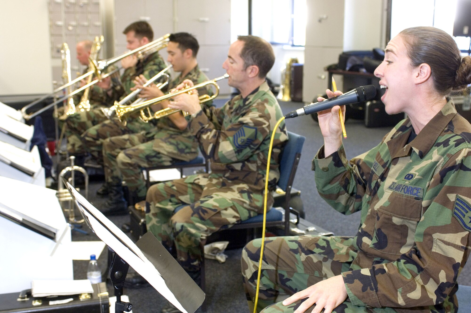 Staff Sgt. Victoria Cronsell rehearses a song as Master Sgt. Andy Held and other U.S. Air Forces in Europe Band members rehearse at Sembach Air Base, Germany, Sept. 22. Sergeant Held is the band NCO in charge and Sergeant Cronsell sings lead vocals for USAFE's jazz band Check Six. (U.S. Air Force photo/Master Sgt. John E. Lasky) 
