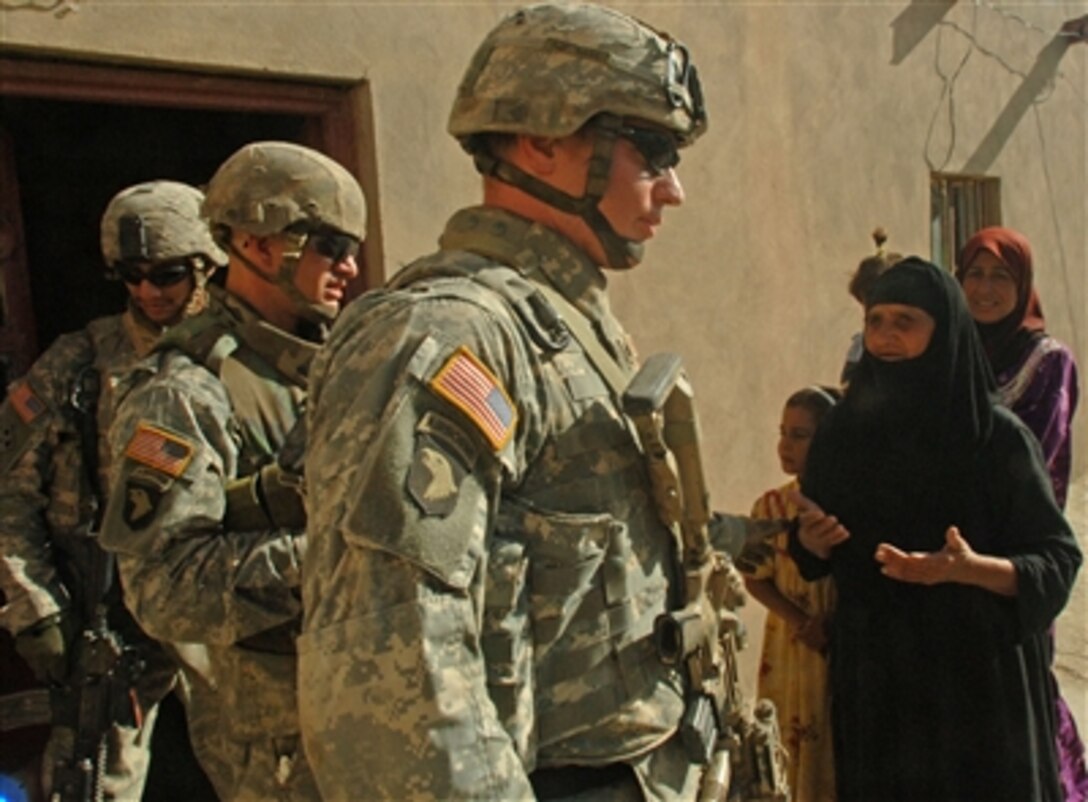 Soldiers from the U.S. Army's Apache Troop, 2nd Squadron, 9th Cavalry Regiment exit a home in Muqdadiyah, Iraq, after searching it on Sept. 20, 2006.  