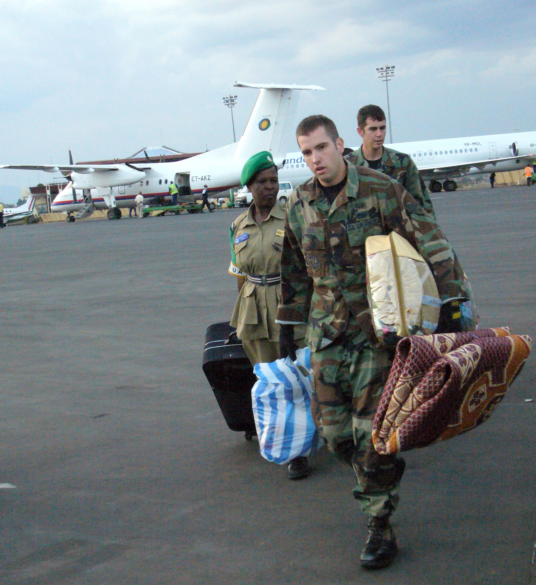 Ramstein Airmen assist Ugandan civil police with their baggage while transfering at Kigali International Airport, Rwanda. The Ugandan civil police are returning home after a one-year deployment to the Darfur region. Airmen from Ramstein Air Base, Germany, are deployed to Kigali, Rwanda, to provide airlift support for the African Union peacekeeping mission. (U.S. Air Force photo/Capt. Erin Dorrance) 