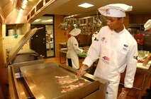 MINOT AIR FORCE BASE -- Airman Jermaine Dias, 740th Missile Squadron, cooks bacon for one of his meals during the 91st Space Wing's 2nd annual Iron Chef Competition Sept. 23, 2006.(U.S. Air Force photo by Airman Sharida Bishop)