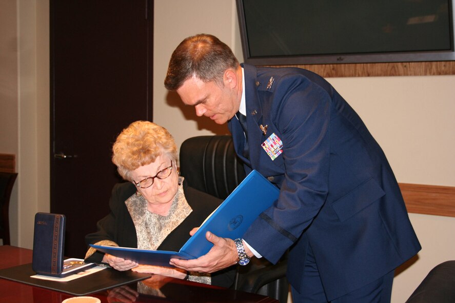 Col. T. Harrison Smith presents Loy Lindsay with her husband's Distinguished Flying Cross. Colonel Smith presided over the ceremony that awarded the DFC to Tech. Sgt. Roscoe Lindsay posthumously 54 years after he flew a classified reconnaissance mission over the Soviet Union in 1952. Colonel Smith is the 22nd Air Refueling Wing vice commander. (U.S. Air Force photo)
