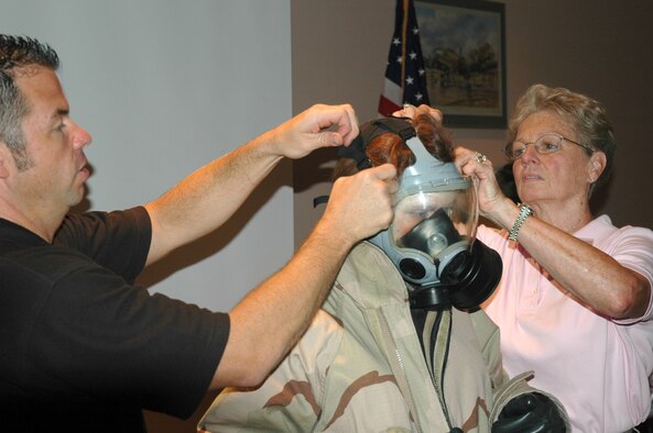 Readiness technician Bob Perreault and employer Marjorie Strickland, far right, assist employer Donna Giarratano with her JSLIST chemical warfare defense ensemble during an Employer Appreciation Day held at Westover Air Reserve Base, Mass. President Bush has named Sept. 24-30 as National Employer Support of the Guard and Reserve Week, during which the nation honors National Guard and Reserve and their civilian employers for their patriotic sacrifice on behalf of America. 