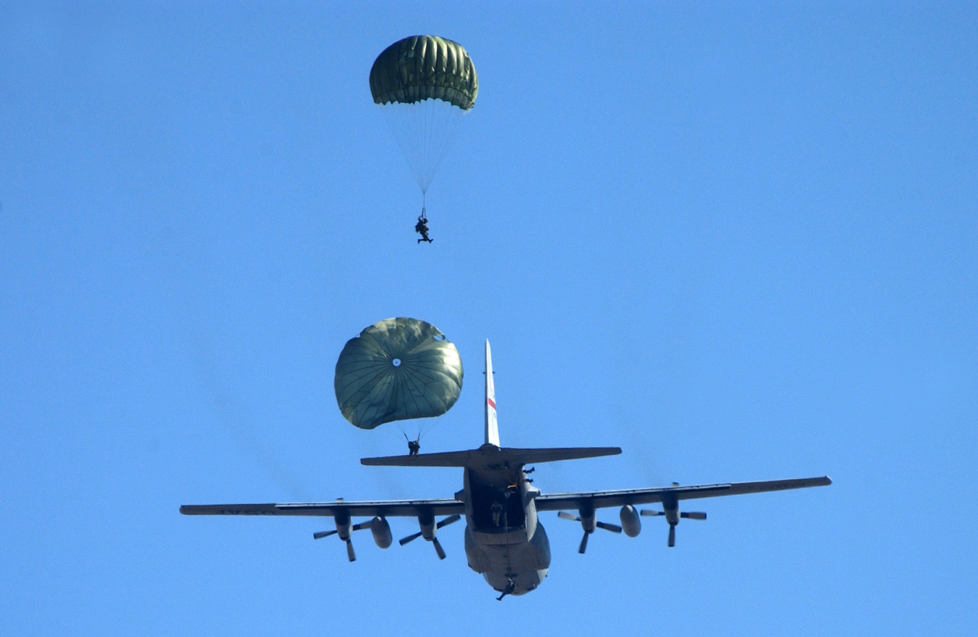 Parajumpers execute a low-level jump out of the back of a C-130 Hercules.  During the Air Force Association's 2006 Air and Space Conference and Technology Exposition in Washington, D.C., Sept. 26, Gen. Duncan J. McNabb, Air Mobility Command commander, said the C-130 missions are being expanded. (U.S. Air Force photo/Staff Sgt. Kenny Kennemer)                      
