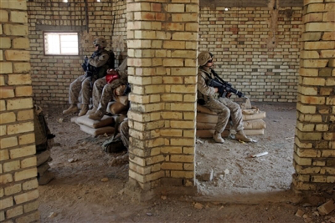 Marines of Weapons Company, 3rd Battalion, 2nd Marine Regiment  take a break from a patrol through a neighborhood east of Husayba, Iraq, Sept. 23, 2006.  The unit patrolled house-to-house to meet with local Iraqis and deter insurgent activity.
