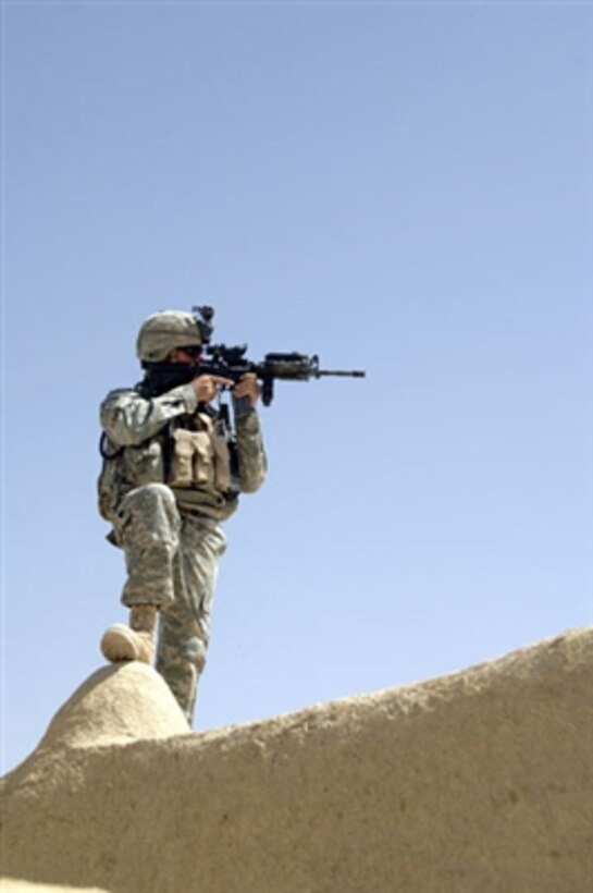 A soldier uses his scope to scan the area as he provides rooftop security for fellow soldiers as they conduct a cordon and search in the village of Alizai in the Ghazni province of Afghanistan on Sept. 13, 2006.  The soldiers are with Delta Company, 2nd Battalion, 4th Infantry Regiment, 10th Mountain Division.  
