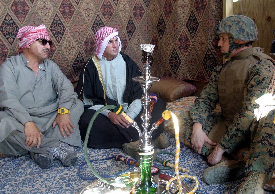Captain Will Markham (right), the commander of the 26th Marine Expeditionary Unit's Marine Air Control Group Detachment, confers with Gunnery Sgt. Michael Gay, also with MACG Det., and an actor from Strategic Operations, a battlefield effects company inside a simulated Arab Sheikh's dwelling.  Strategic Operations provided actors, pyrotechnics and props to add realism to the MEU's training.  (Official USMC photo by Lance Cpl. Jeremy T. Ross) (Released)