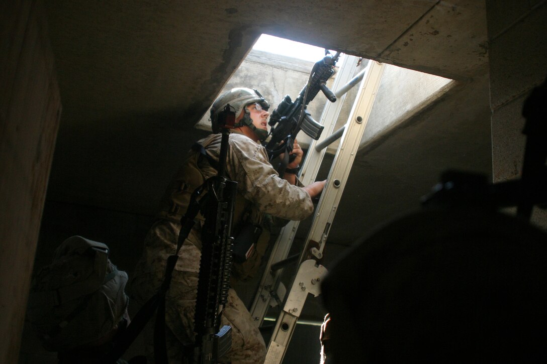 Corporal Robert L. Sullivan of Company G, Battalion Landing Team, 2nd Bn., 2nd Marine Regiment, 26th Marine Expeditionary Unit, climbs a ladder to get to a suspected gunman during a street patrol at the Military Operations in Urban Terrain facility at Fort Pickett, Va., Sept. 28, 2006. The 26th MEU was training at Fort Pickett for their Marine Expeditionary Unit Exercise.