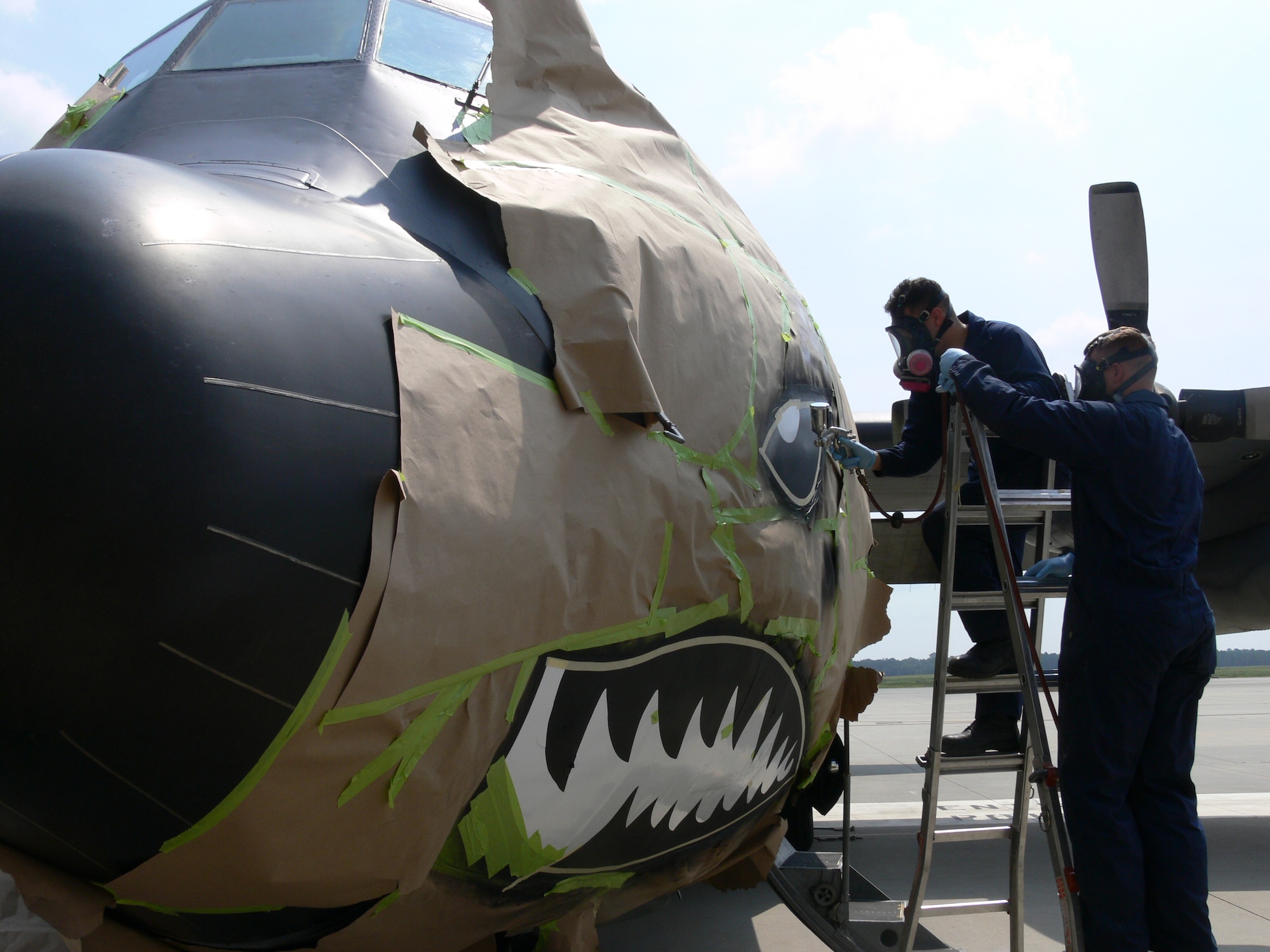 Airmen 1st Class Ernesto Sosa and Nicholas Heimgartner paint the nose of a C-130E in August at Moody Air Force Base, Ga. The aircraft was repainted to represent the 347th Rescue Wing's upcoming transition to the 23rd Wing, known as the famous "Flying Tigers." The 347th RQW will deactivate and the 23rd Wing will activate Sept. 29. Airmen Sosa and Heimgartner are from the 347th Maintenance Squadron at Moody AFB. (U.S. Air Force photo/Airman 1st Class Eric Schloeffel)