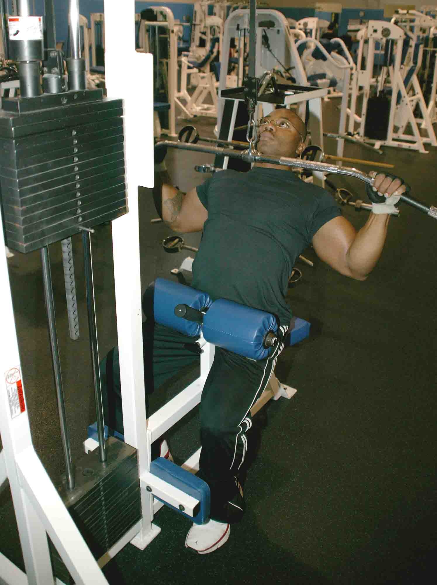Staff Sgt. Malcolm Drinks, 55th AMU crew chief, demonstrates how to properly perform lateral pull-downs. (U.S. Air Force photo/Senior Airman John Gordinier)