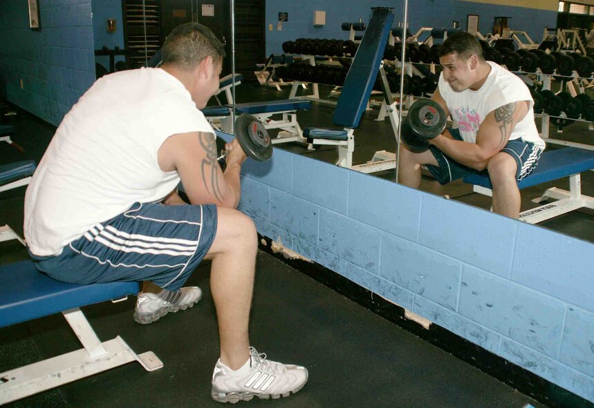 Senior Airman Dominic Arvizu, 77th Aircraft Maintenance Unit crew chief, performs some bicep curls in his daily workout Wednesday at the Shaw fitness center. (U.S. Air Force photo/Senior Airman John Gordinier)