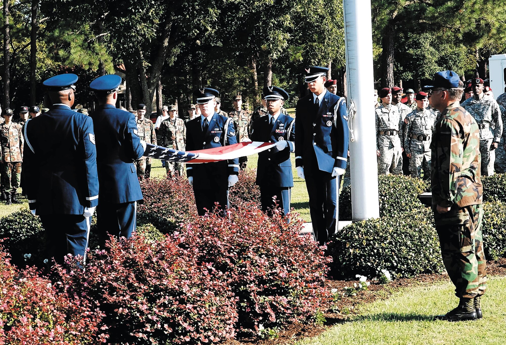 Col. John McDonald, 43rd Airlift Wing vice commander, looks on as the ceremonial knights of the Pope Honor Guard team fold the American flag at a retreat ceremony Tuesday. The ceremony rounded out the day of the Installation Excellence Award inspection with the 82nd Airborne All-American Chorus singing to the masses. (U.S. Air Force photo/Mike Murchison)