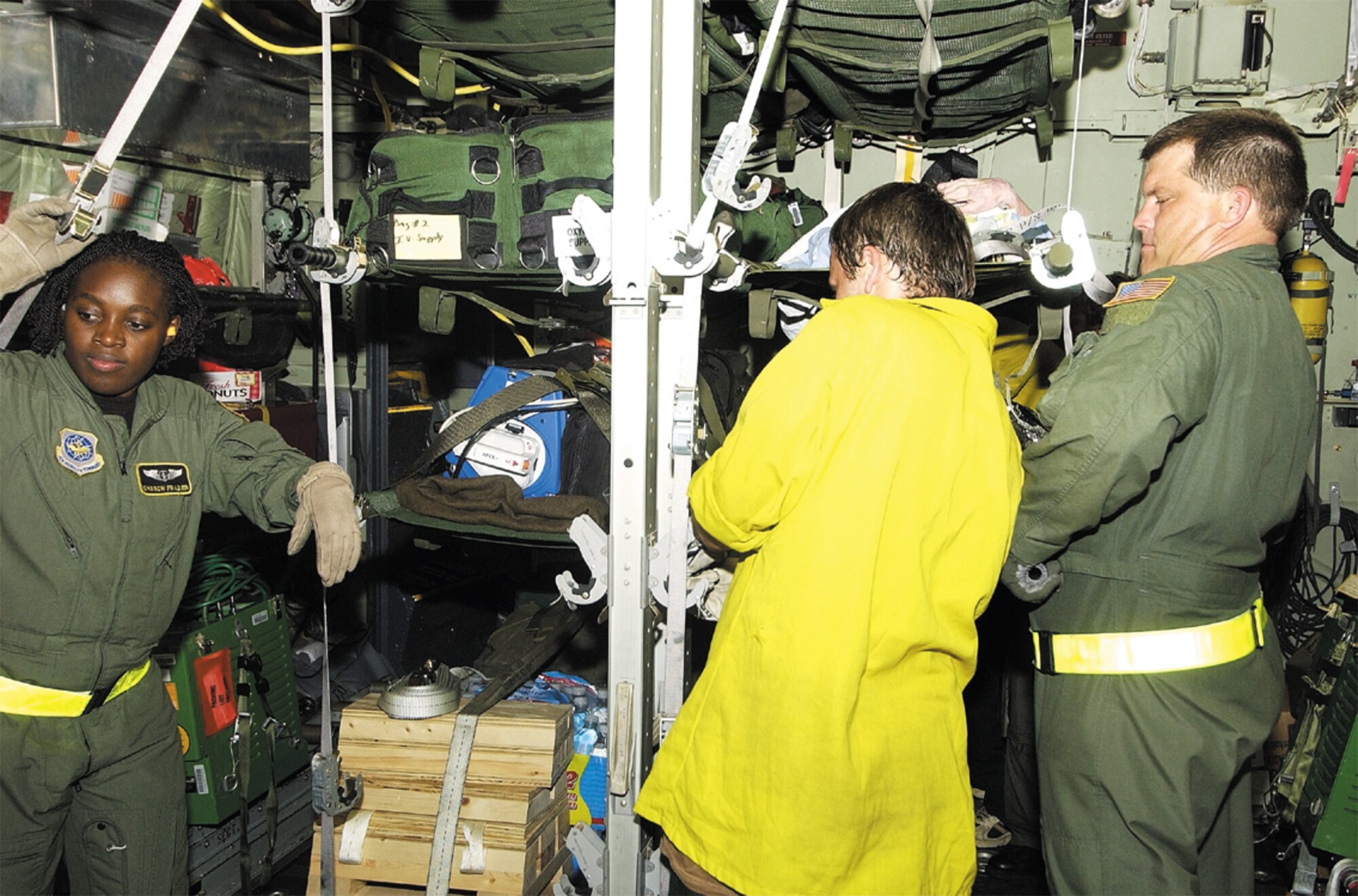 Capt. Sharon Frazier and Master Sg. Ricky Webb, 43rd Aeromedical Evacuation Squadron, along with a volunteer Forest Service worker, load patients onto a C-130 at Louis Armstrong International Airport in New Orleans, La., during the aftermath of Hurricane Katrina. (Courtesy photo)