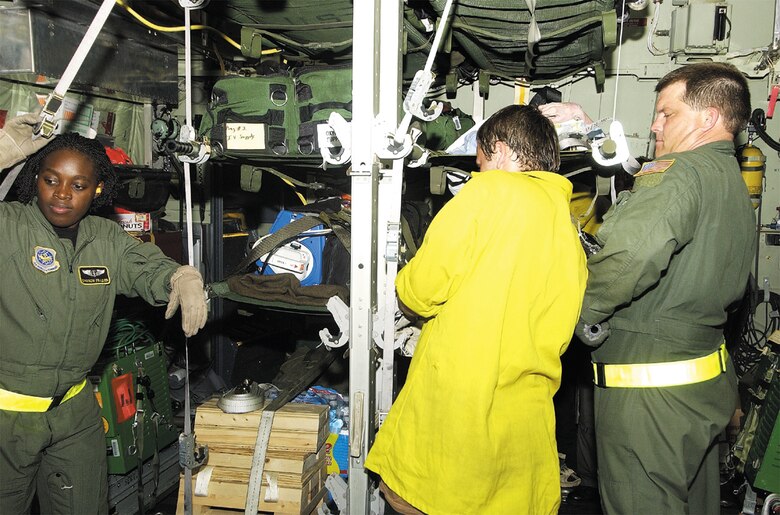 Capt. Sharon Frazier and Master Sg. Ricky Webb, 43rd Aeromedical Evacuation Squadron, along with a volunteer Forest Service worker, load patients onto a C-130 at Louis Armstrong International Airport in New Orleans, La., during the aftermath of Hurricane Katrina. (Courtesy photo)