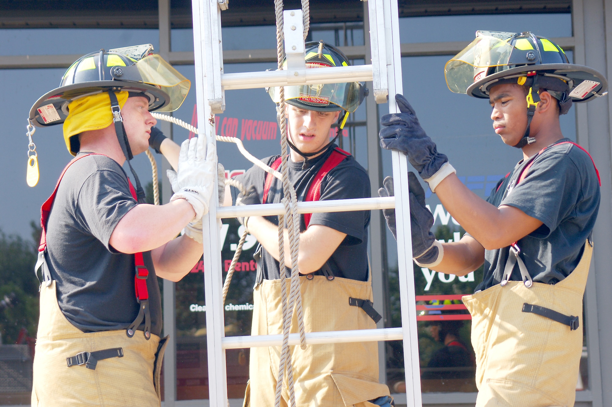 From left, Airman 1st Class Timothy Day, Airman Adam Stephen and Senior Airman Jamar Adams, 20th Civil Engineer Squadron Fire Department firefighters, raise a ladder Sept. 19 to check for more fire on the roof of the 5000 area shopette. (U.S. Air Force photo/Airman 1st Class Katherine Dodd) 
