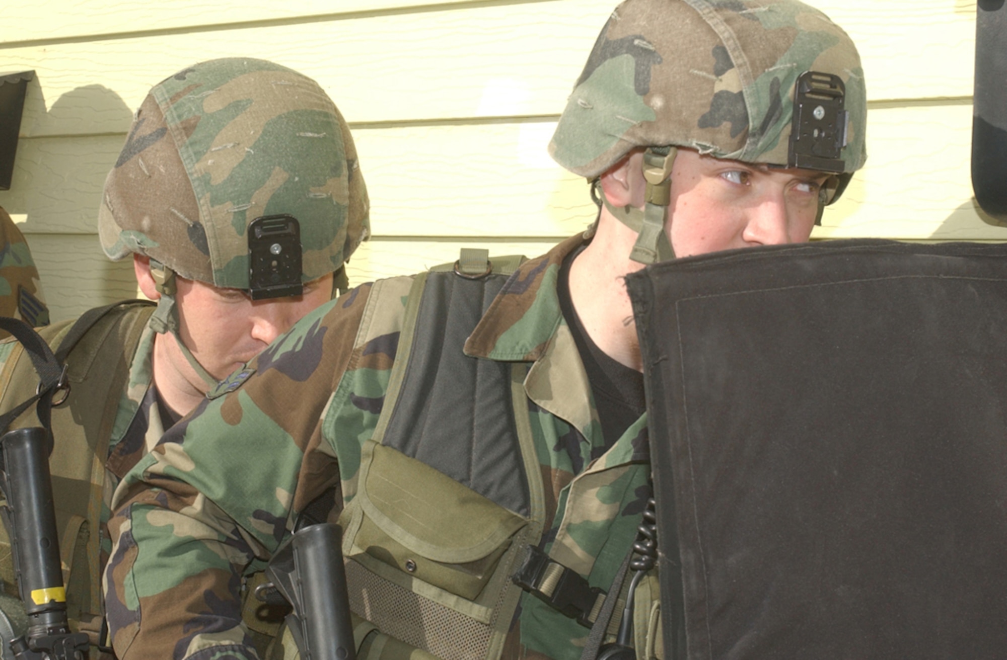Airman 1st Class William Hancock, right, and Staff Sgt. Zachary Elliott, left, prepare to enter a base housing unit during Tactical Response Force training.