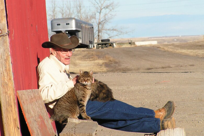 Walter Henley basks in the afternoon sun with two of his many four-legged friends at the Malmstrom stables. Mr. Henley is a seasoned horseman who provides help and advise to many other horse owners on base.  
