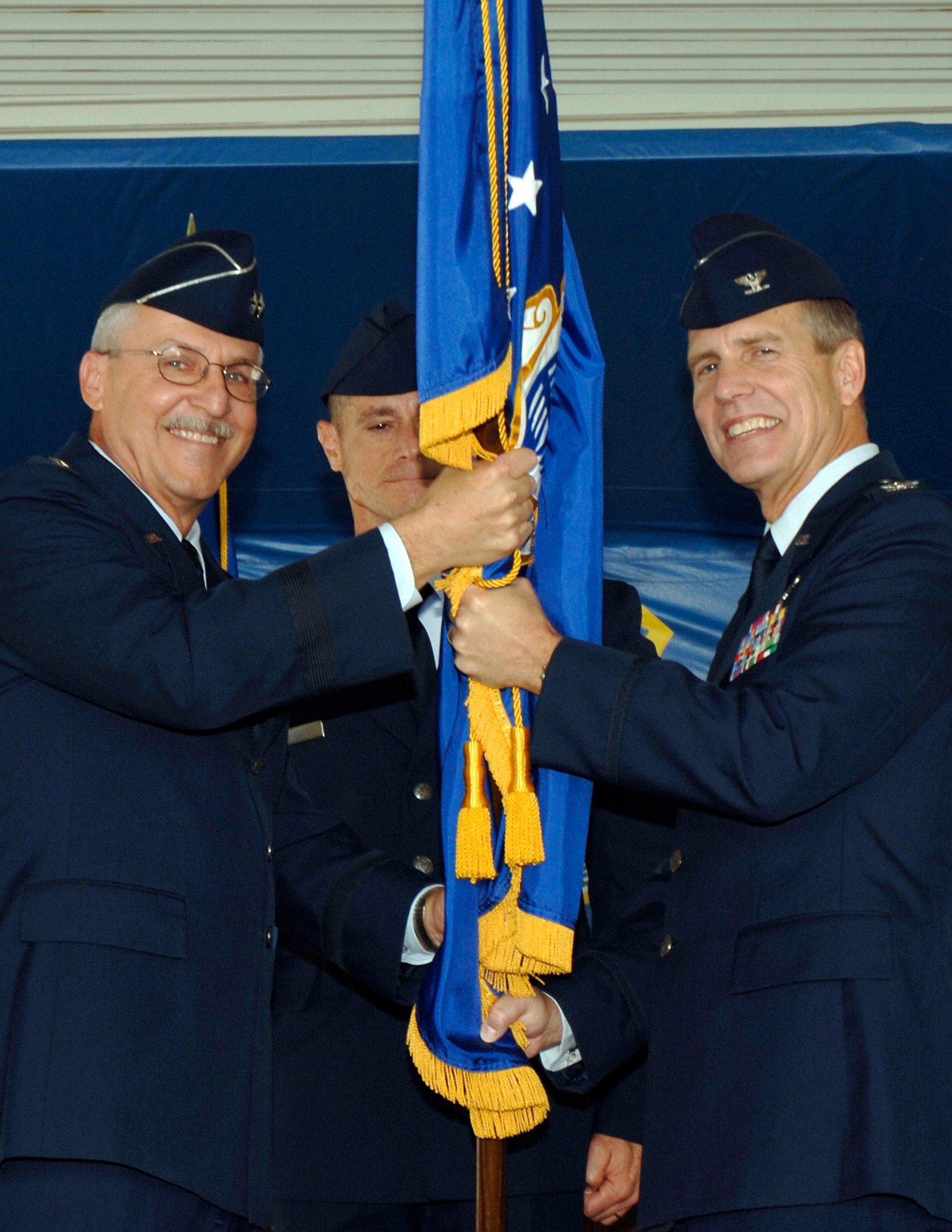 Changing of the guard: Maj. Gen. Martin Mazick, 22nd Air Force commander, (left) hands the 315th Alirlift Wing guidon to Col. Timothy Wrighton, new 315th AW commander, during the 315th AW Change of Command ceremony Sept. 17 at Charleston Air Force Base.  (Photo by Staff Sgt. Beatrice Cassetty)