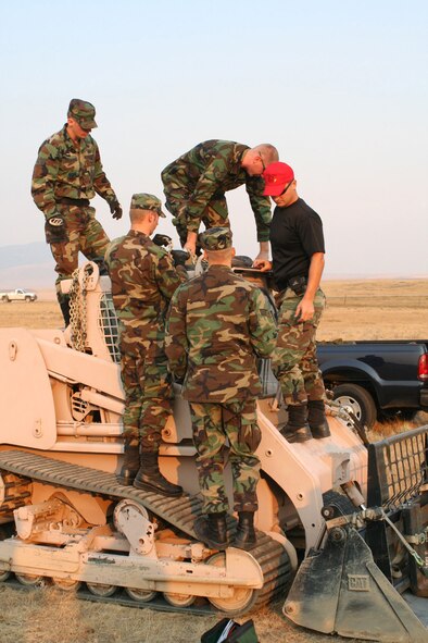 Airborne RED HORSE crew members prepare the caterpillar skid-steer loader to be sling-loaded from the work site on West Peak Sept. 13. (U.S. Air Force photo by Capt. Christopher Smith)

