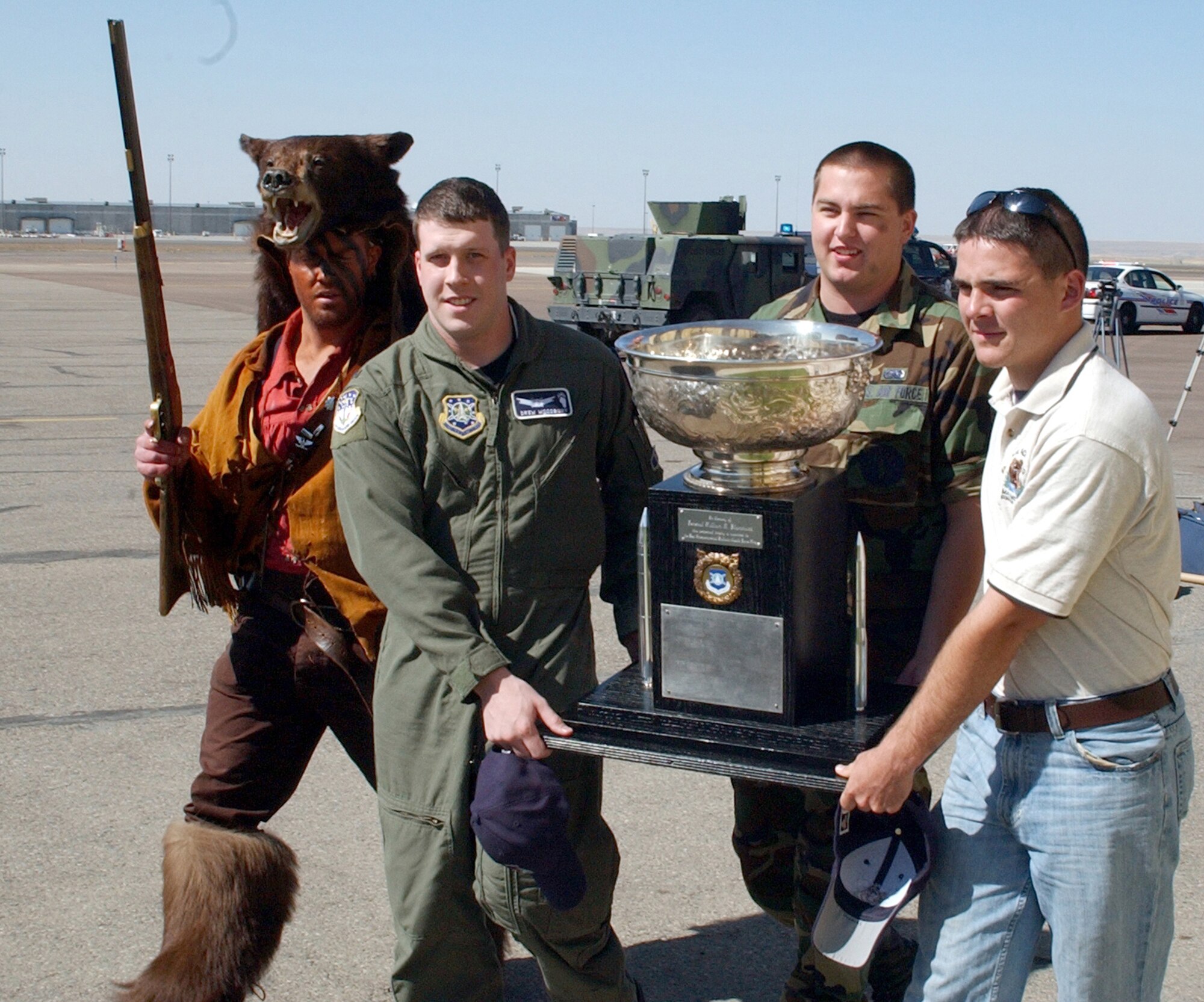 From left to right; 2nd Lt. Chris Dauer (a.k.a. "Grizz"), 341 MMXS, 1st Lt. Drew Woodbury, 341 OSS, Senior Airman Sam Jennings, 341 MMXS, and Airman First Class Christopher Stephens, 341 MSFS, escort the Blanchard Trophy from a C-17 onto a bus at the Great Falls International Airport Saturday.  All were members of the 2006 Malmstrom Guardian Challenge Team.    