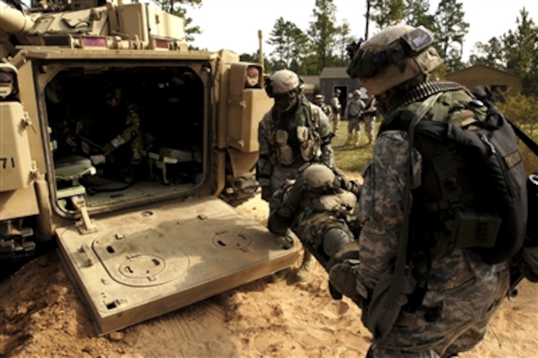 U.S. Army soldiers from the 2nd Battalion, 7th Infantry Regiment, 3rd Infantry Division load a simulated casualty into an M113 armored personnel carrier during a mission readiness exercise at Fort Stewart, Ga., Sept. 25, 2006. 