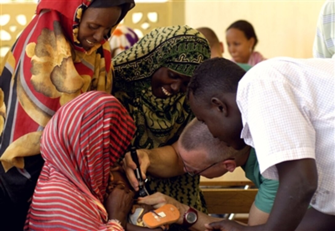 U.S. Navy Lt. Cmdr. Christopher Hults, a surgeon from Naval Hospital Jacksonville, Fla., checks the ear of a patient Sept. 13, 2006, during a medical civic action program in Assamo, Djibouti, in support of Combined Joint Task Force - Horn of Africa. 
