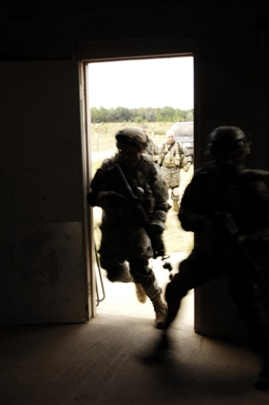 U.S. Army soldiers from 1st Battalion, 41st Field Artillery Regiment, 1st Brigade, 3rd Infantry Division rush into a building during a simulated raid as part of a mission readiness exercise at Fort Stewart, Ga., on Sept. 25, 2006.  