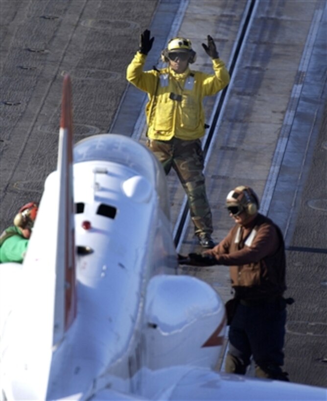 U.S. Navy Petty Officer 2nd Class Rodney Martinez guides a T-45 Goshawk training aircraft into position for launch from the deck of the aircraft carrier USS Theodore Roosevelt (CVN 71) on Sept. 24, 2006. Martinez is a Navy Aviation Boatswain's Mate.  