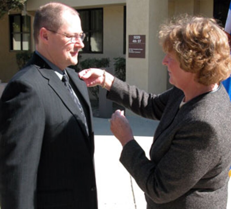 Assistant Auditor General of the Air Force Ms. Judy Simon promotes Mr. Ron Prentkiewicz, Air Force Audit Agency, March Air Reserve Base, Calif., to the rank of GS-15.  Ms. Simon promoted three local auditors to the highest GS grade during a recent ceremony at the base. (U.S. Air Force photo by Maj. Don Traud)