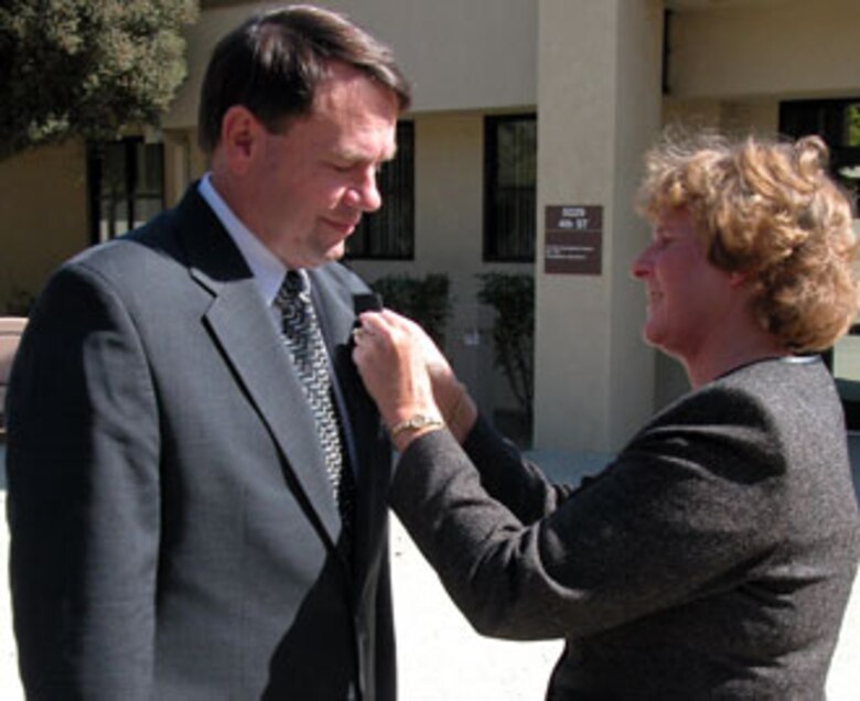 Assistant Auditor General of the Air Force Ms. Judy Simon promotes Mr. James Stahle, Air Force Audit Agency, March Air Reserve Base, Calif., to the rank of GS-15.  Ms. Simon promoted three local auditors to the highest GS grade during a recent ceremony at the base. (U.S. Air Force photo by Maj. Don Traud)