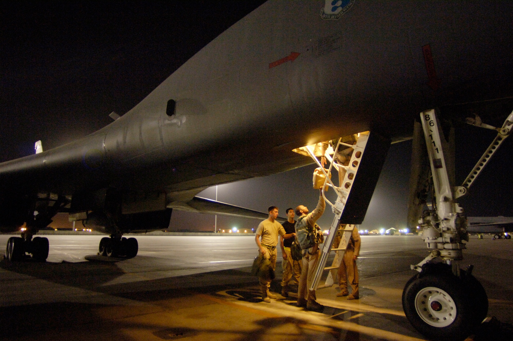 Capt. Cedric Harper, Senior Airman Kyle Stackpole and Airman 1st Class Justin Bailey load supplies into a B-1 Lancer for a 12-hour sortie over Southwest Asia Sept. 28. Captain Harper is a B-1 weapons systems officer and Airmen Stackpole and Bailey are crew chiefs. They are deployed from Ellsworth Air Force Base, S.D. (U.S. Air Force photo/Master Sgt. Scott Wagers) 
