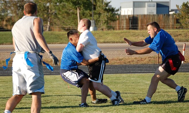 Josh Mills, quarterback for the 566th Information Operations Squadron's intramural flag football team, smacks into 460th Operation Supports Squadron's Jason Banda during a game Tuesday afternoon. 460th OSS won, 6-0. (U.S. Air Force photo by Senior Airman Jacque Lickteig)