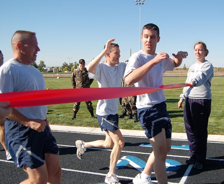 Curtis Vancel, Kevin Candler and David Ziegler break the ribbon to mark the finished inaugural lap around Buckley?s new track. The track opened Monday, about a month and a half ahead of schedule. (U.S. Air Force photo by Senior Airman Jacque Lickteig)

