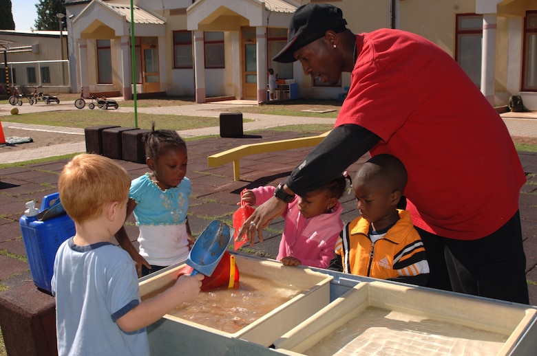 Tyrone Dukes, also known as Mr. T by his students, plays with the children at the water table at the Child Development Center Sept. 23.  (U.S. Air Force photo by Airman 1st Class Nathan Lipscomb)