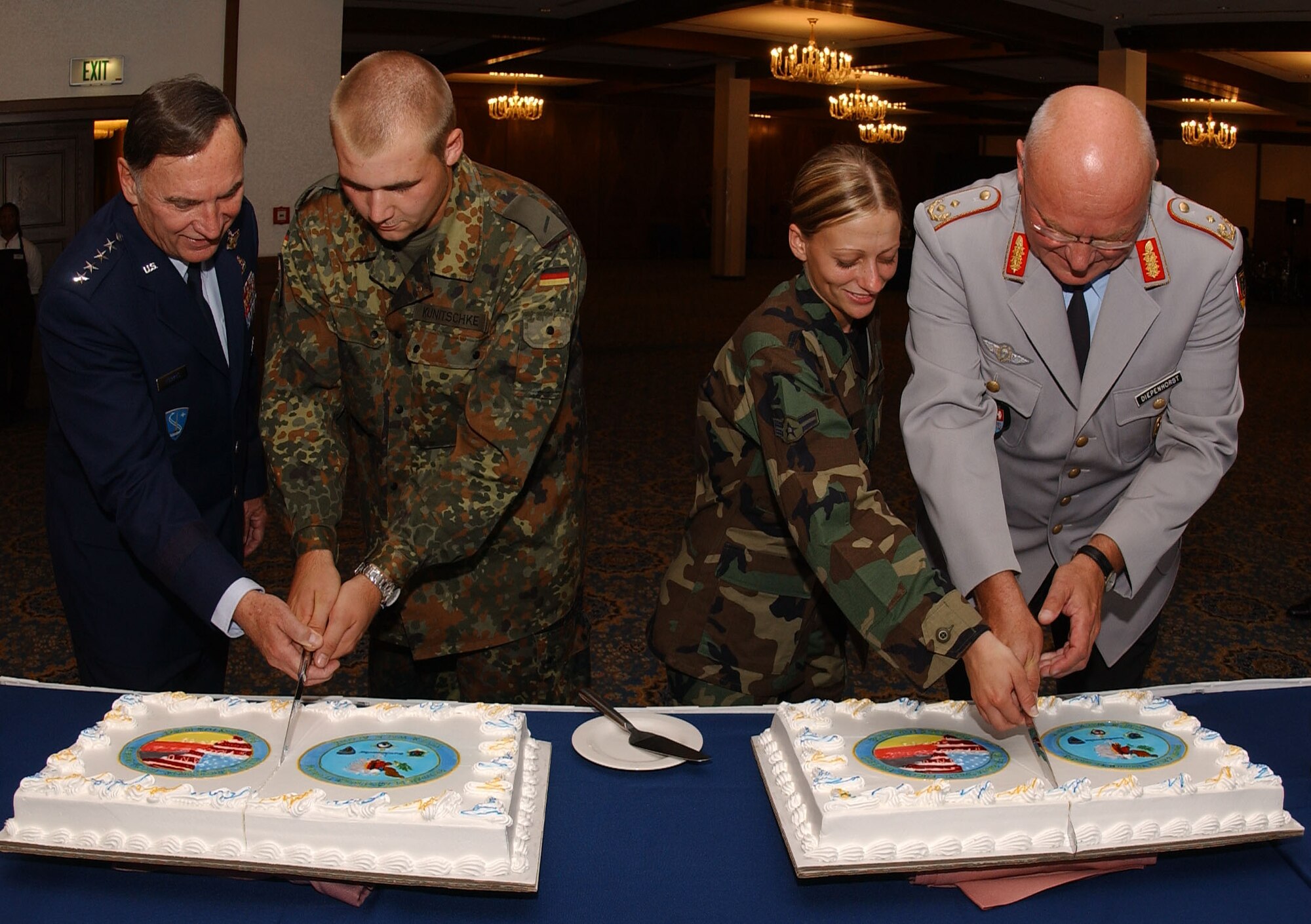 (Left to right) Gen. Tom Hobbins, U.S. Air Forces in Europe commander; Pvt. Christian Kunitschke, German Army; Airman 1st Class Bobbie Ohm, 435th Security Forces Squadron; and Maj. Gen. Bernd Diepenhorst, German Army, cut the cakes during a Sept. 28 ceremony honoring the departure of the German Bundeswehr after the conclusion of more than three years of guarding the gates at USAFE bases in Germany. Nineteen-year-old Private Kunitschke and 20-year-old Airman Ohm represented the youngest servicemembers from each military to help celebrate the event. (U.S. Air Force photo/Airman 1st Class Levi Riendeau)
