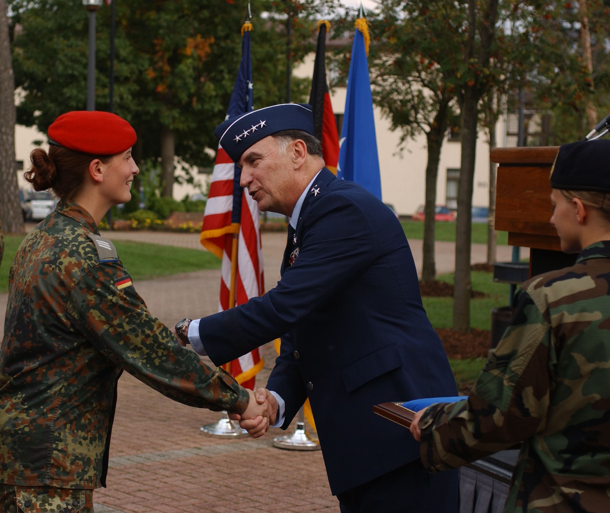 Gen. Tom Hobbins, U.S. Air Forces in Europe commander, presents a coin to Pfc. Ricarda Franke of the German Army during a Sept. 28 ceremony honoring the departure of the German Bundeswehr after the conclusion of more than three years of guarding the gates at USAFE bases in Germany. (U.S. Air Force photo/Airman 1st Class Levi Riendeau)
