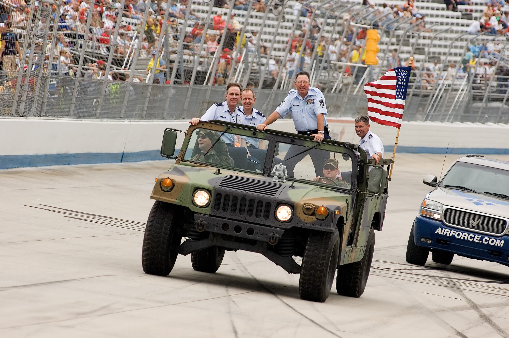 (Left to right) Brig. Gen. Robert McMahon, Air Mobility Command Director of Logistics, Scott Air Force Base, Ill.; Col. David Wuest, 512th Airlift Wing vice commander; Chief Master Sgt. Bruce Blodgett, 436th AW command chief; and Col. Sam Cox, 436th AW commander, cruise in a parade lap around Dover International Speedway before the 400-lap Nextel Cup series race Sunday. Master Sgt. Dave Guenthner, 512th Civil Engineer Squadron, is driving the Humvee, and Master Sgt. Jeremy Henner, 436th CES, is riding shotgun. Both sergeants are from the Explosive Ordnance Disposal team here. (U.S. Air Force photo/Roland Balik)