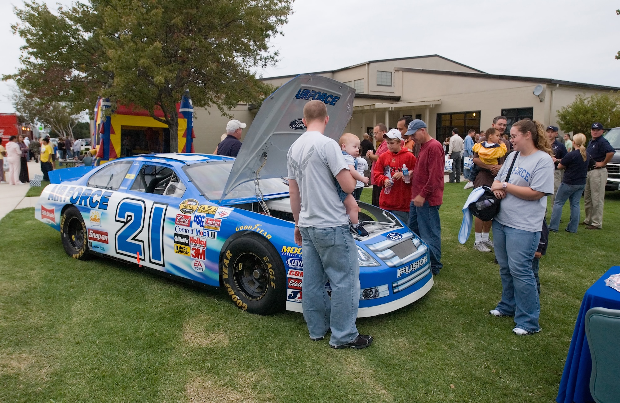 Delayed Enlistment Program Recruits and other members check out the engine on the #21 Air Force car, which is driven by Kenny Schrader, at the NASCAR Social Friday night at The Landings Club. Members enjoyed free pizza, drinks and live music while socializing with their favoite NASCAR celebrities. (U.S. Air Force photo/Jason Minto)