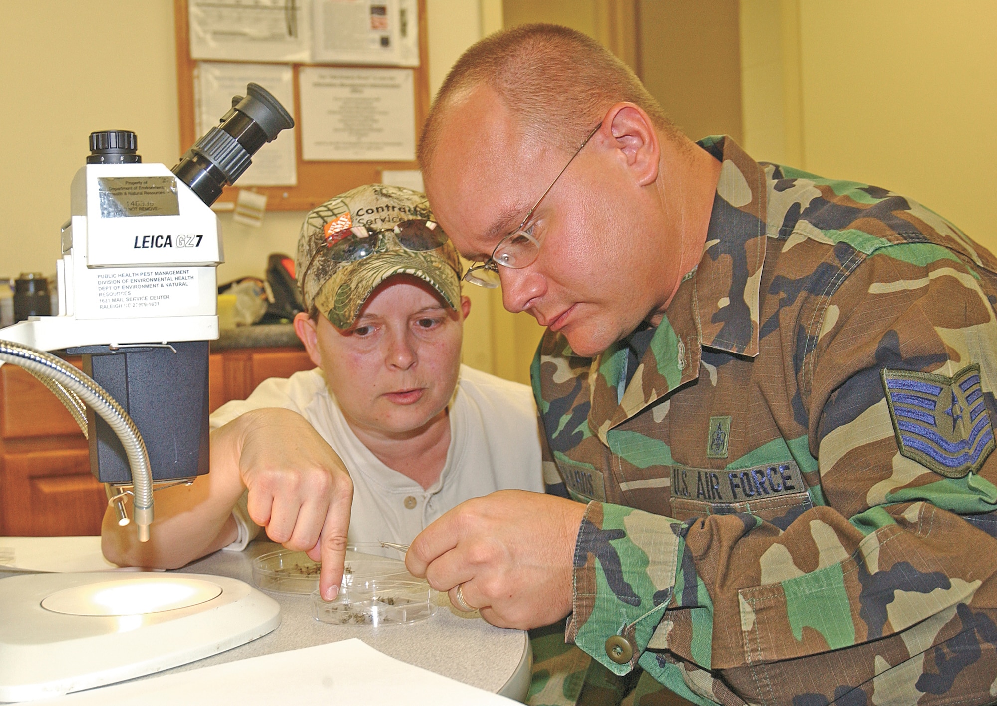 Janet Driggers, North Carolina Public Health environmental specialist, and Tech. Sgt. Kevin Richards, NCO-in-charge of base public health, sort the collection of mosquitoes so they can be identified to determine their species.  After they are properly identified and separated, they are sent to state labs for testing. (Photo by Master Sgt. Art Webb)                              