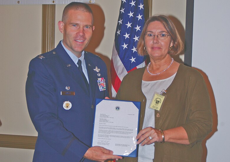 Col. Steve Kwast, 4th Fighter Wing commander, presents the Retiree Volunteer of the Year award to Betty Cassidy, secretary of the Retiree Activities Office. (Photo by Staff Sgt. Les Waters)                              