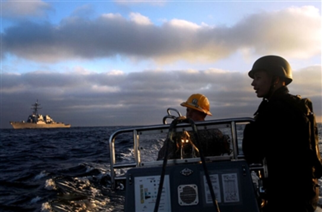 Petty Officer 2nd Class Michael Fornengo and Petty Officer 2nd Class Nicholas Rowe, USS Paul Hamilton, stand by to pick up their Visit, Board, Search and Seizure team members as they board a civilian ship during an exercise in the Pacific Ocean, Sept. 26, 2006. 