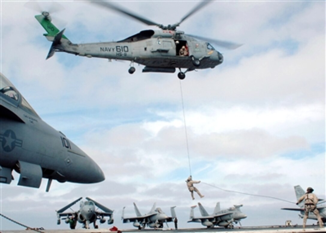 Explosive Ordnance Disposalmen conduct a fast-rope exercise from an SH-60F Seahawk helicopter aboard the USS John C. Stennis in the Pacific Ocean, Sept. 28, 2006. 