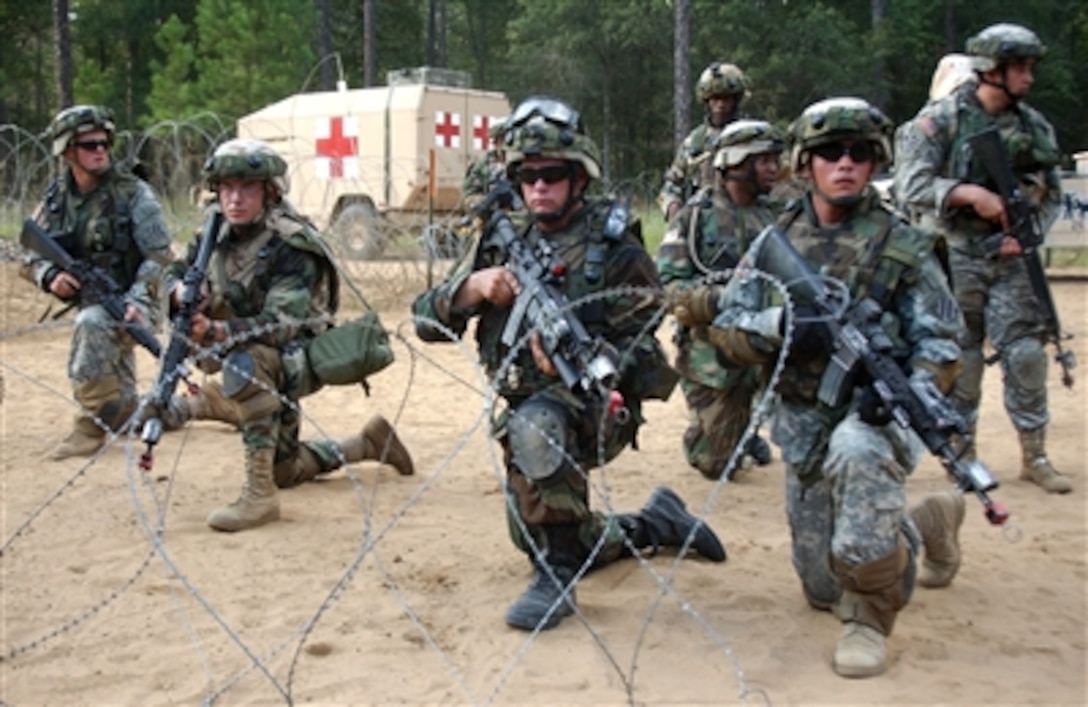 U.S. Army soldiers from 1st Brigade, 3rd Infantry Division tighten up security at the front gate of a mock Forward Operating Base during a mission readiness exercise at Fort Stewart, Ga., being held in preparation for an upcoming deployment to Iraq, Sept. 26, 2006.  